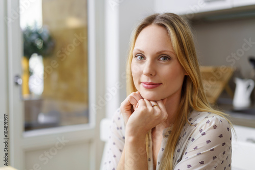 attraktive blonde frau sitzt in ihrer wohnung