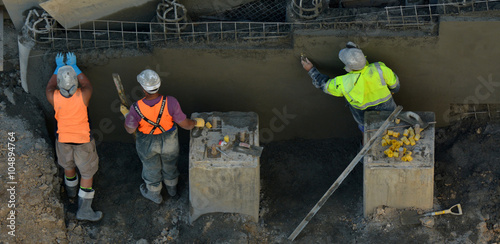 Concrete plaster men smoothing concrete wall