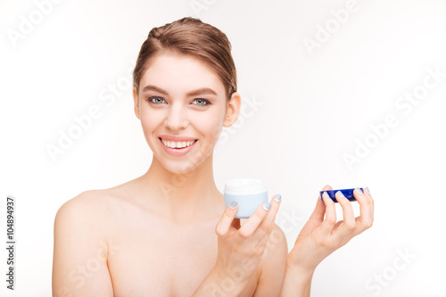 Smiling cute woman holding facial cream