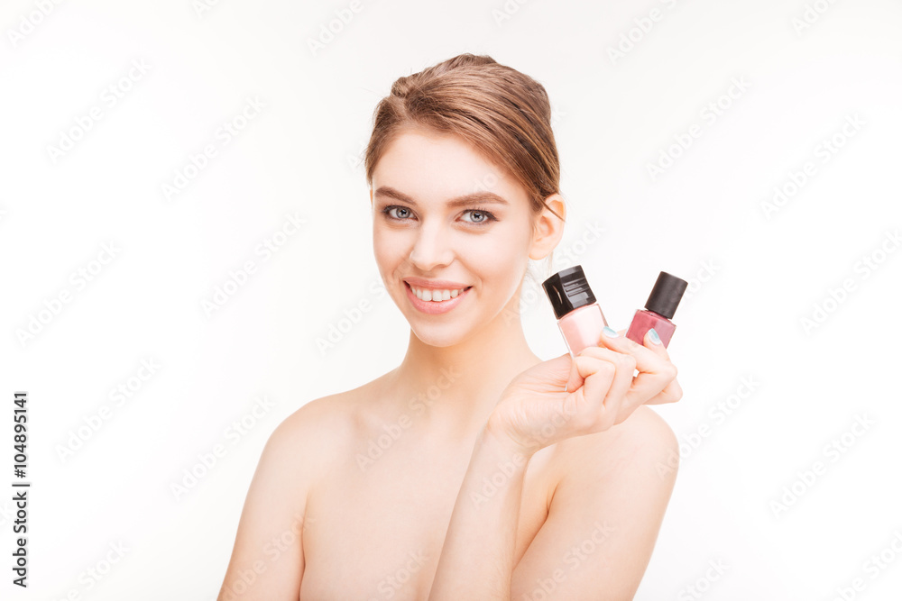 Beauty portrait of cheerful young woman holding nail polishes Beauty portrait of cheerful young woman holding nail polishes