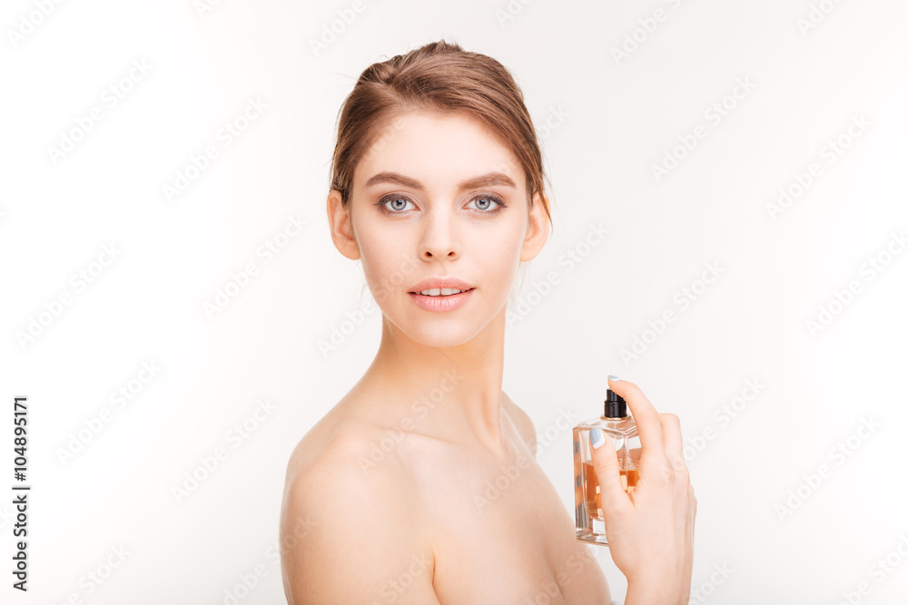 Pretty young woman holding bottle of parfume Pretty young woman holding bottle of parfume