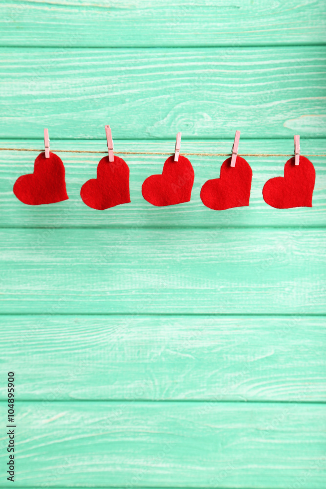 Love hearts hanging on rope on a mint wooden background