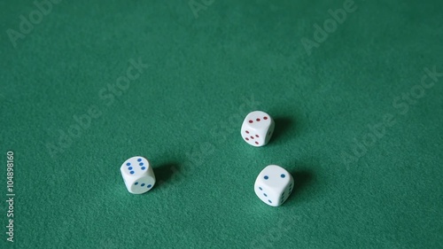 A hand of a man throwing three white dice on the green cloth. Slow motion. photo