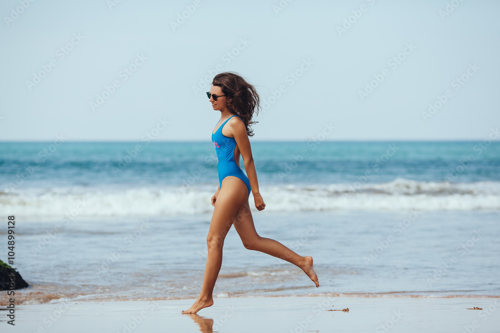 Running woman. Female runner jogging during outdoor workout on b Running woman. Female runner jogging during outdoor workout on b