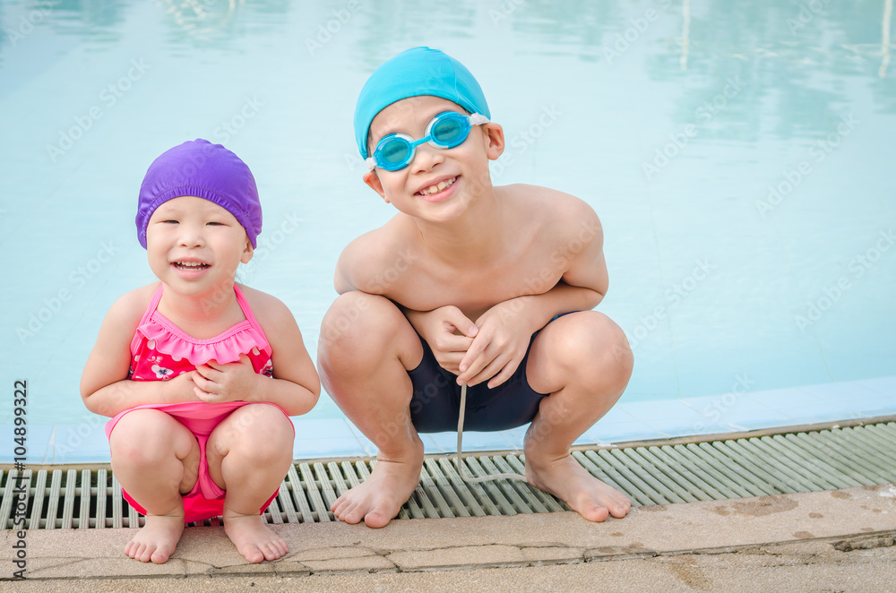 Children in swim suit sitting at swim pool