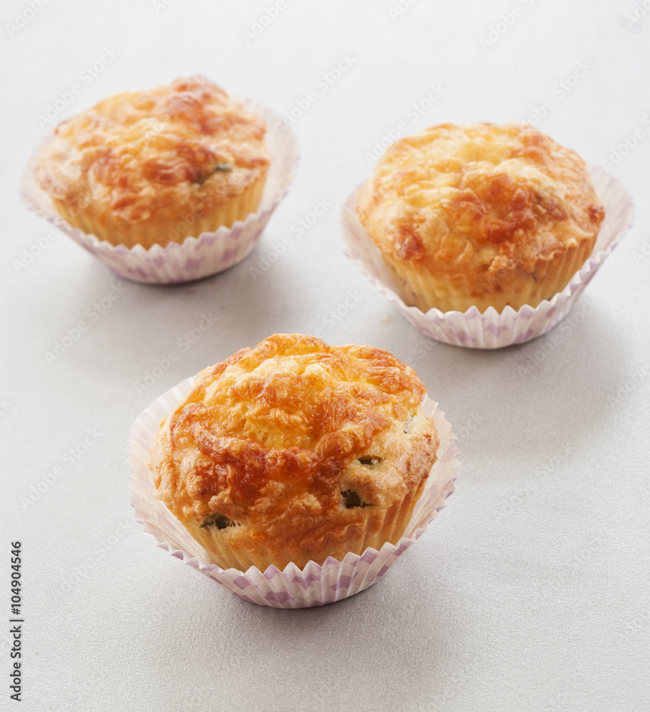 Savory cheese and bacon muffins on the white wooden table Savory cheese and bacon muffins on the white wooden table