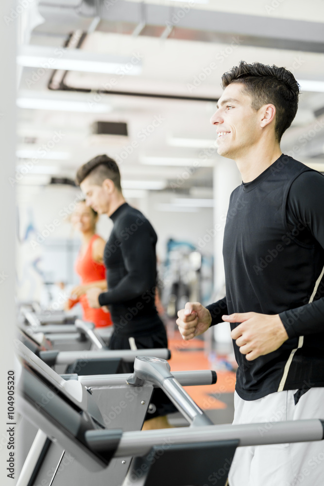 Group of young people using treadmills in a gym Group of young people using treadmills in a gym