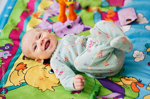 Happy little baby smiling laying in bed