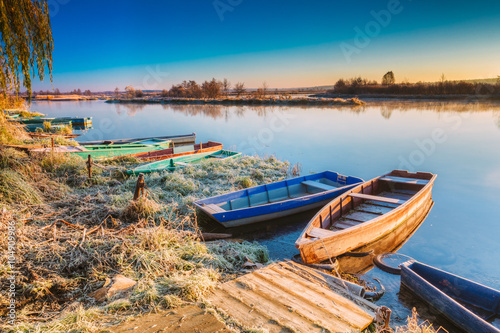 River and old wooden rowing fishing boat at beautiful sunrise in