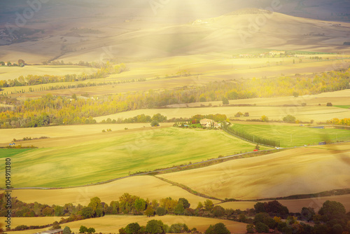 Wavy fields in Tuscany at sunet, Italy. Natural outdoor seasonal autumn background with sun shining