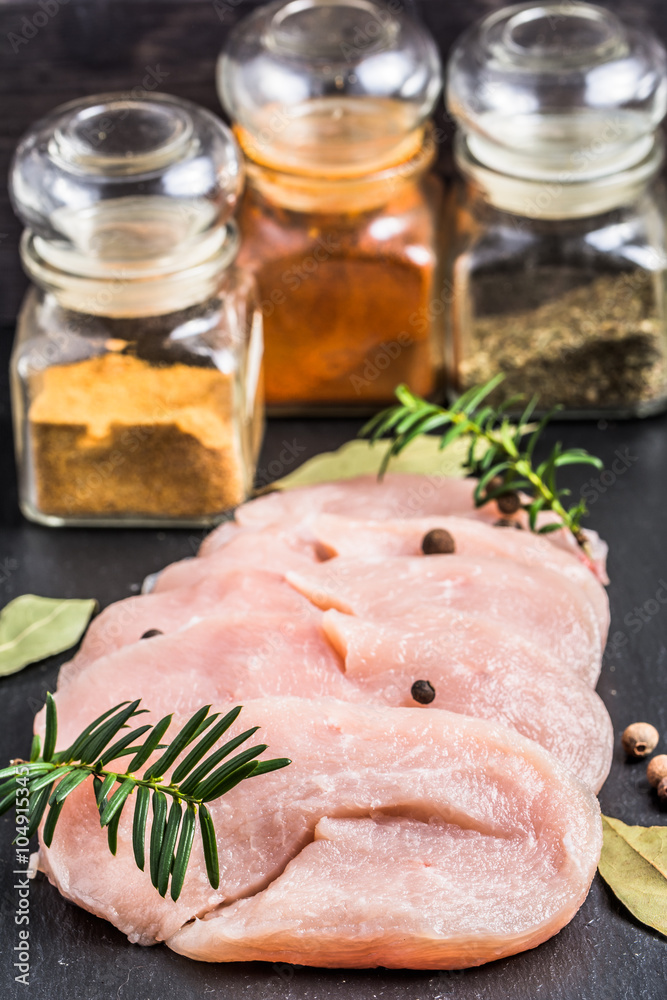 Raw turkey breast slices with spices on table. Raw turkey breast slices with spices on table.