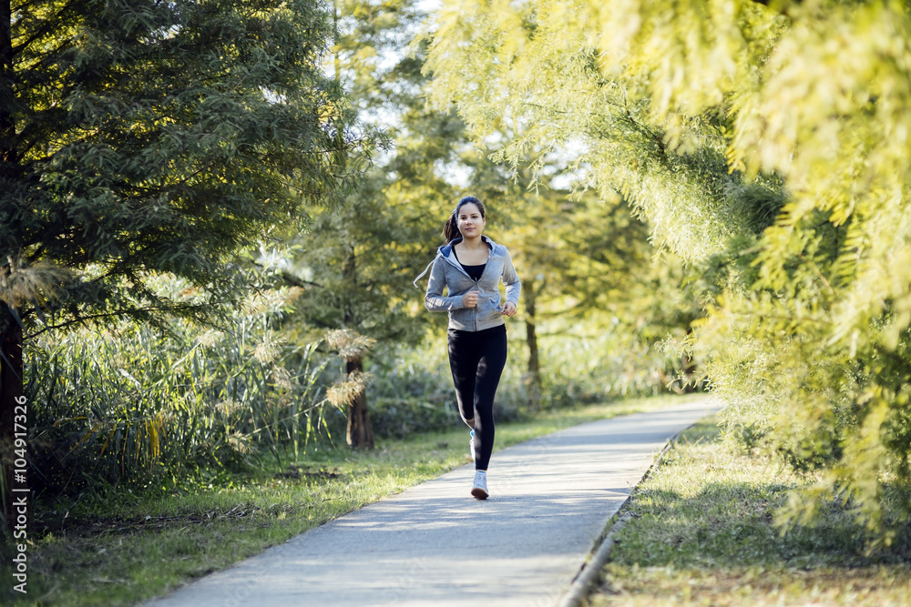 Fit beautiful woman jogging in park