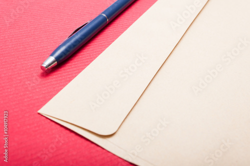 Point of view of envelop and pen on office table