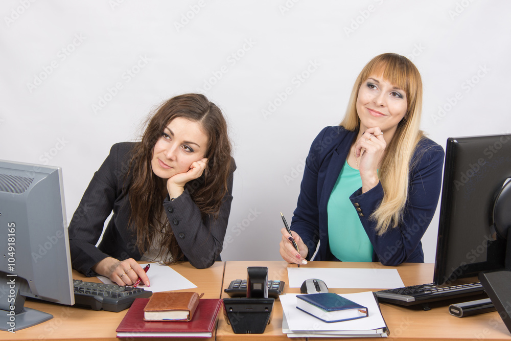 The situation in the office - two women dreaming, sitting at a desk The situation in the office - two women dreaming, sitting at a desk