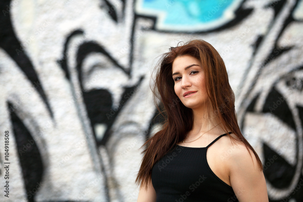 Sexy girl with black top standing in front of a wall with graffiti Sexy girl with black top standing in front of a wall with graffiti