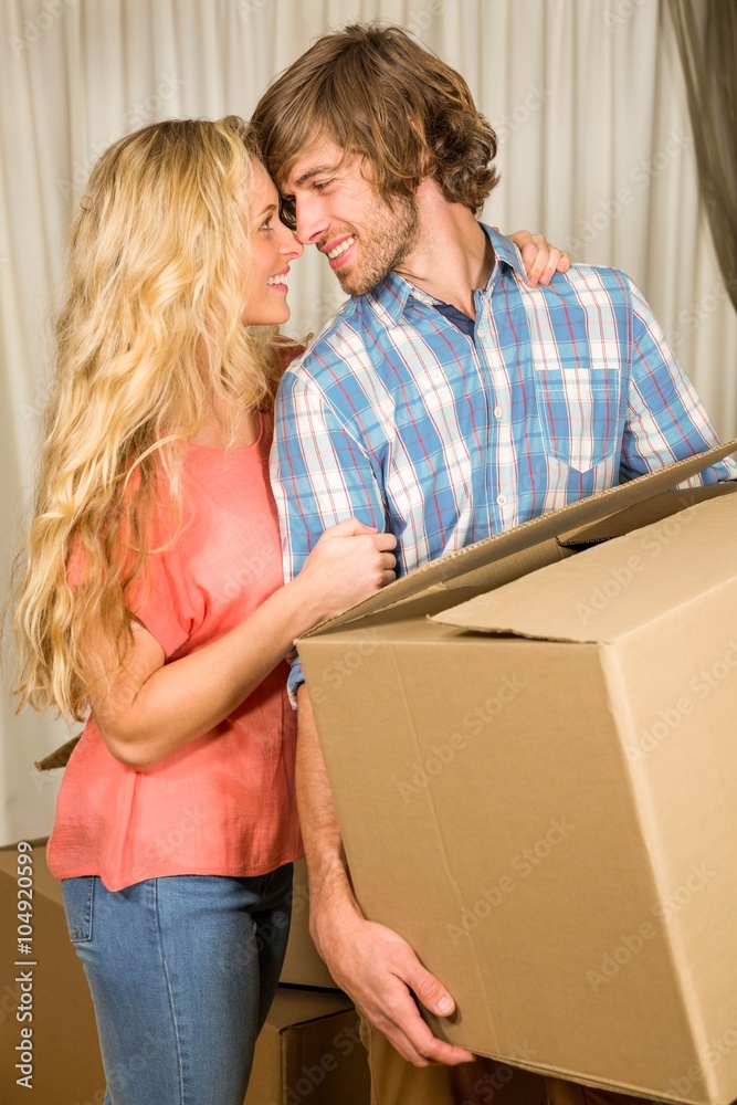 Happy couple embracing with moving box Happy couple embracing with moving box