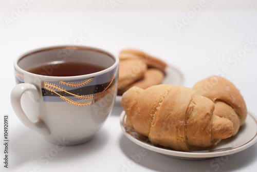 Fototapeta Naklejka Na Ścianę i Meble -  Cup of tea with pattern and fresh croissants