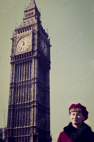 Original vintage colour slide from 1960s, young woman poses for a holiday snap with houses of parliament in London.