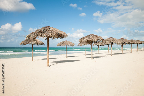 Umbrellas from royal palm leaves, parasole on sandy beach in Var © Samo Trebizan