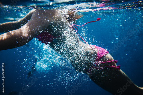 Woman swimming underwater in an ocean © 4Max