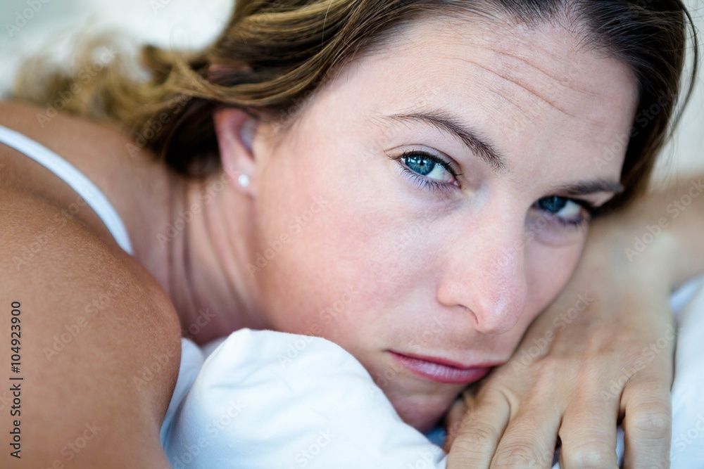 woman lying with her head on her hands looking sad woman lying with her head on her hands looking sad