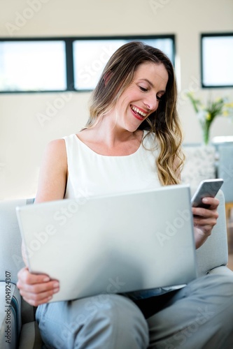 smiling woman on her laptop and mobile phone
