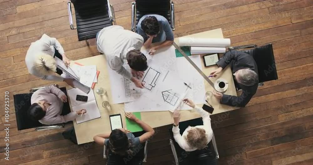 Top View of Business people meeting around boardroom table discussing architectural plans for new sustainable shared office space
