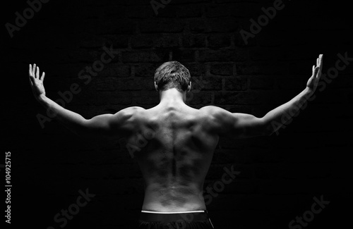 Silhouette of a strong, athletic man with dramatic light and dark background