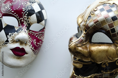 Two Venetian carnival masks on a light background