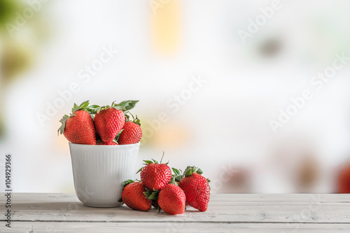 Red strawberries in a white cup