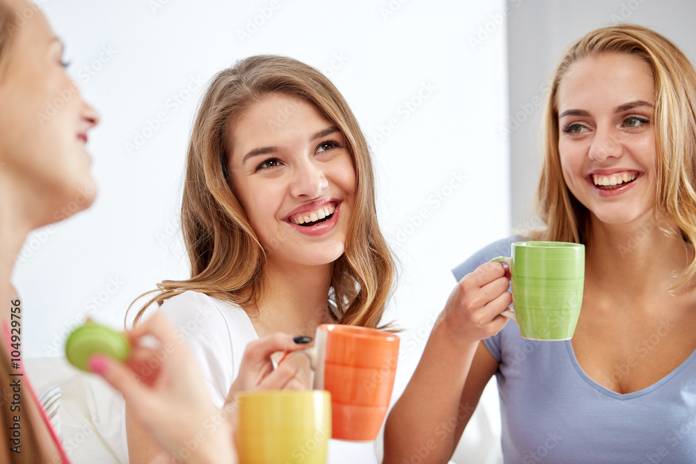 happy young women drinking tea with sweets at home happy young women drinking tea with sweets at home
