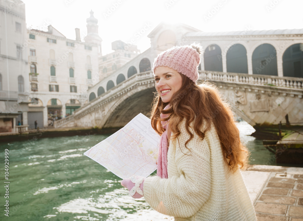 Fototapeta premium Woman tourist with map near Rialto Bridge looking on Grand Canal