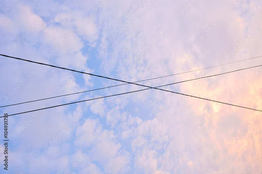 Electrical wires crossing over each other in the evening sky Electrical wires crossing over each other in the evening sky