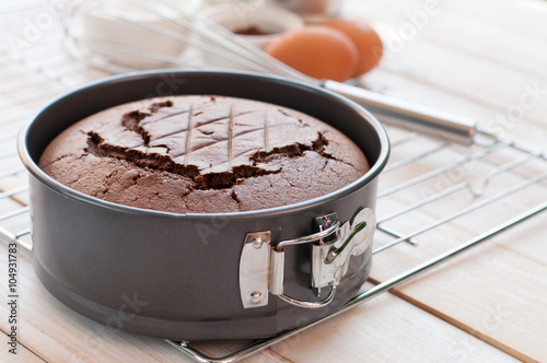 Chocolate cake in cake form on wooden background