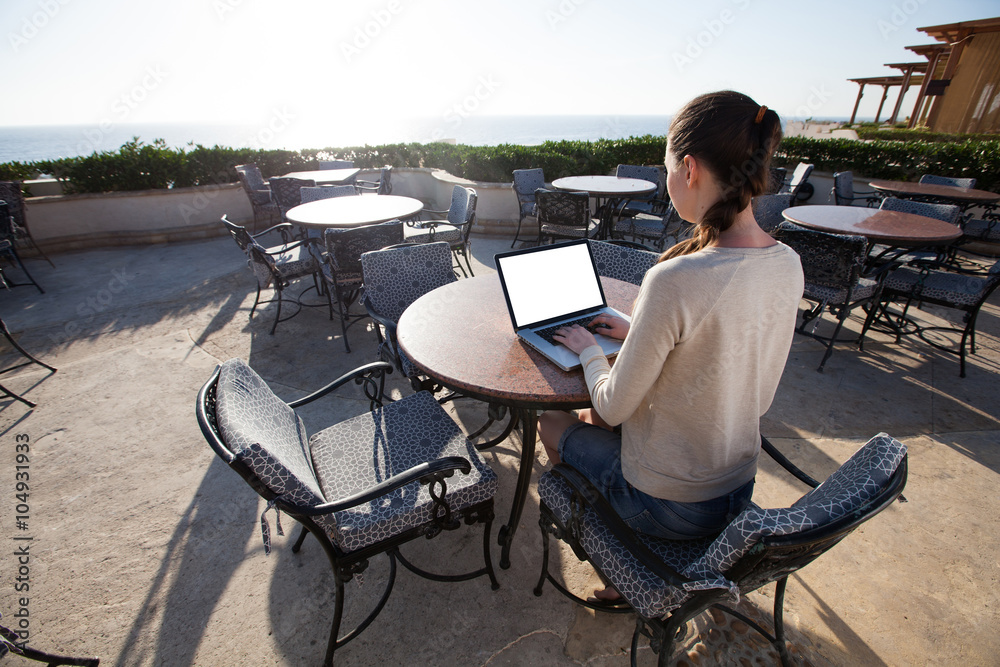 businesswoman typing on her laptop with sunflare on the resort