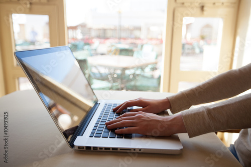 Woman sitting using laptop inside