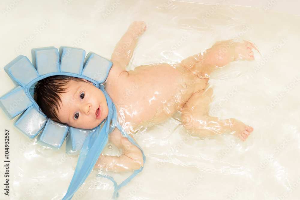 Baby girl swiming in the bath with special blue swiming mutch