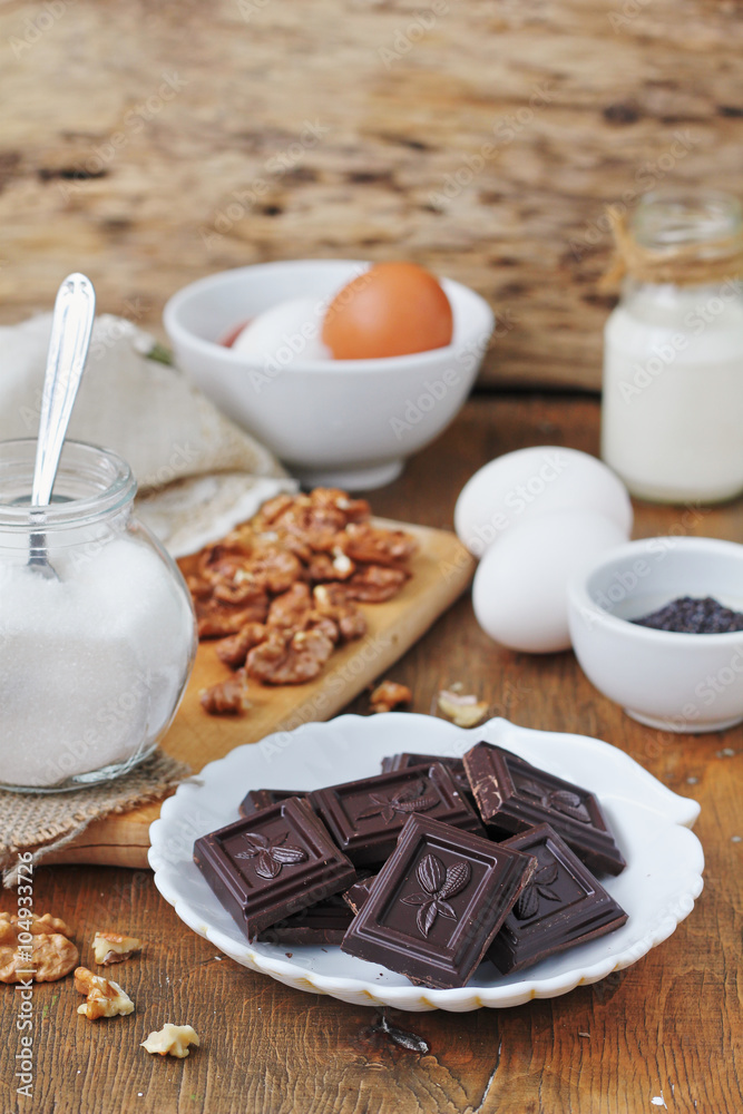 Ingredients for baking cake: chocolate, walnuts, eggs, milk, sugar and flour