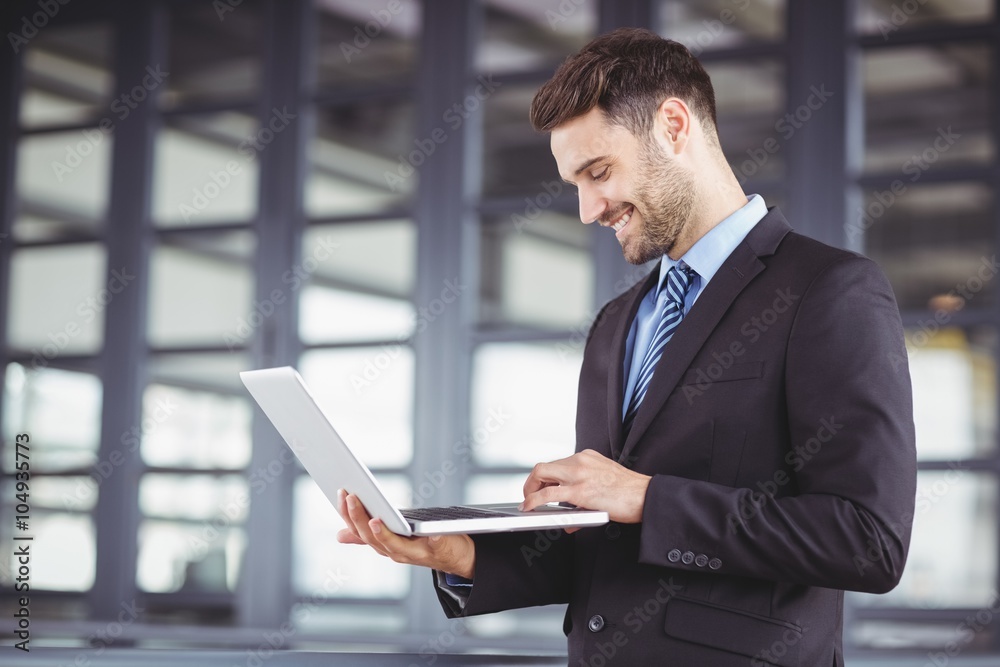 Businessman smiling while using laptop