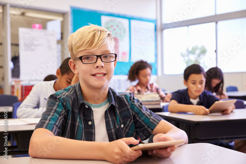 Boy with tablet in elementary school class, portrait