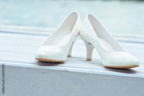 white wedding shoes on wooden background