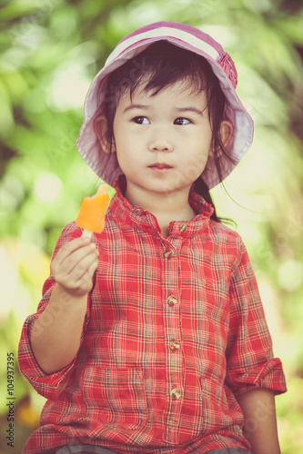Asian girl eating ice cream in the summer on blurred nature background.