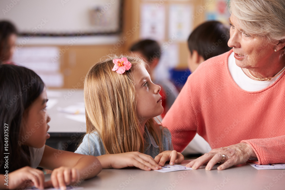 Senior teacher helping pupils in elementary school lesson Senior teacher helping pupils in elementary school lesson