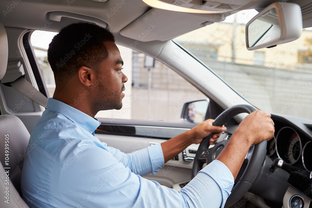 In car view of young male African American driving a car