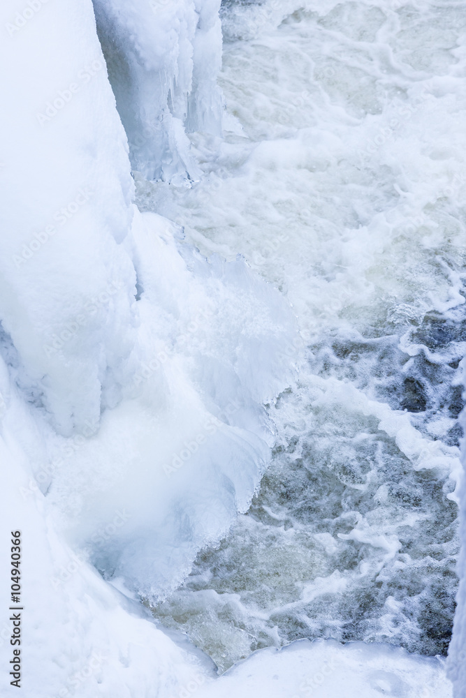 Icicles and snow near flowing water Icicles and snow near flowing water
