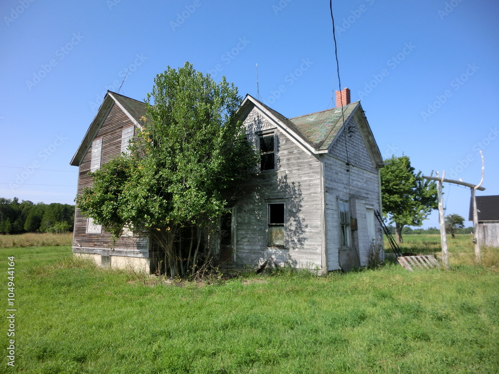 Obraz premium Abandoned weathered wooden farmhouse exterior - landscape color photo