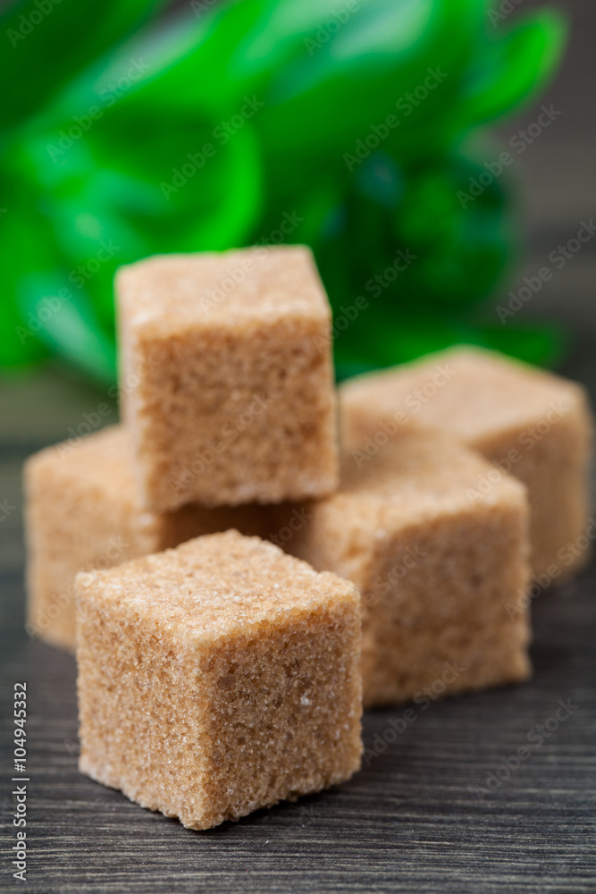 Brown lump sugar on rustic wooden board