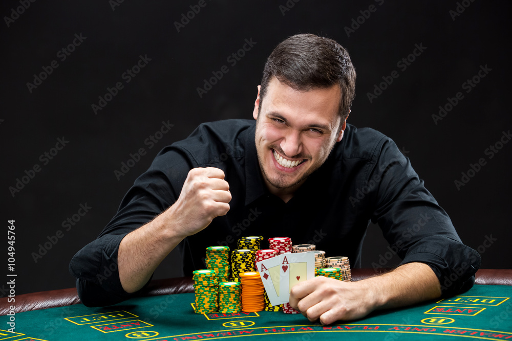Happy poker player winning and holding a pair of aces Happy poker player winning and holding a pair of aces