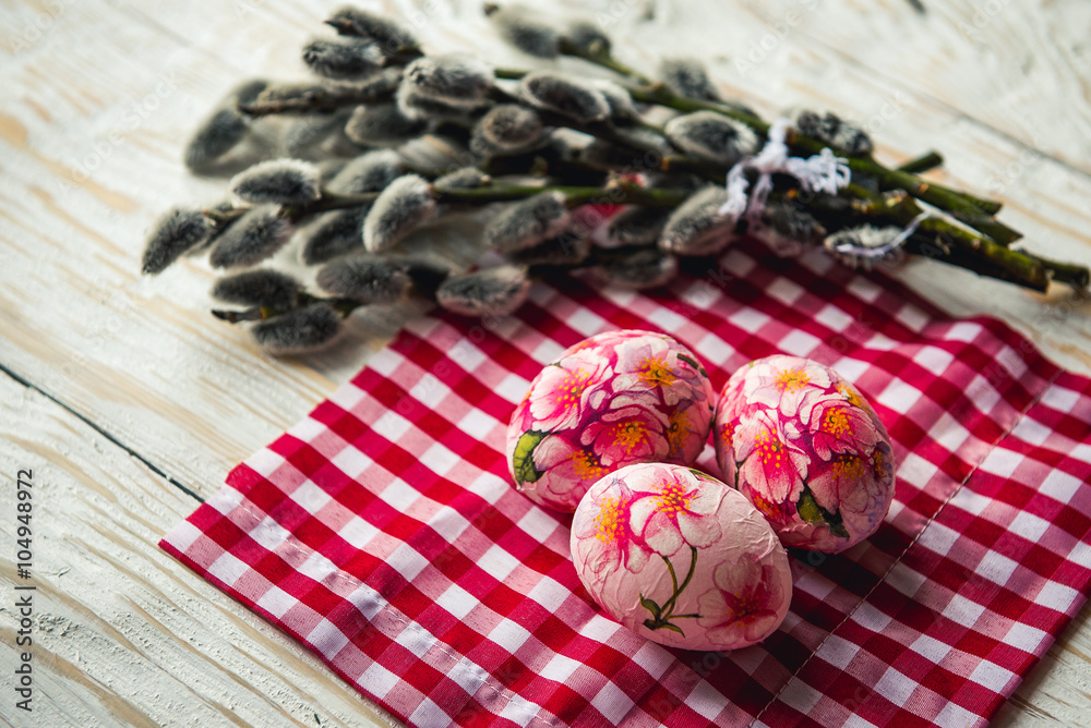 Easter eggs with pussy willow on light background