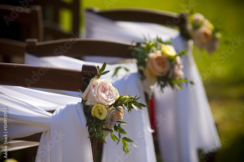 Sedie addobbate per una cerimonia di matrimonio all'aria aperta. photo